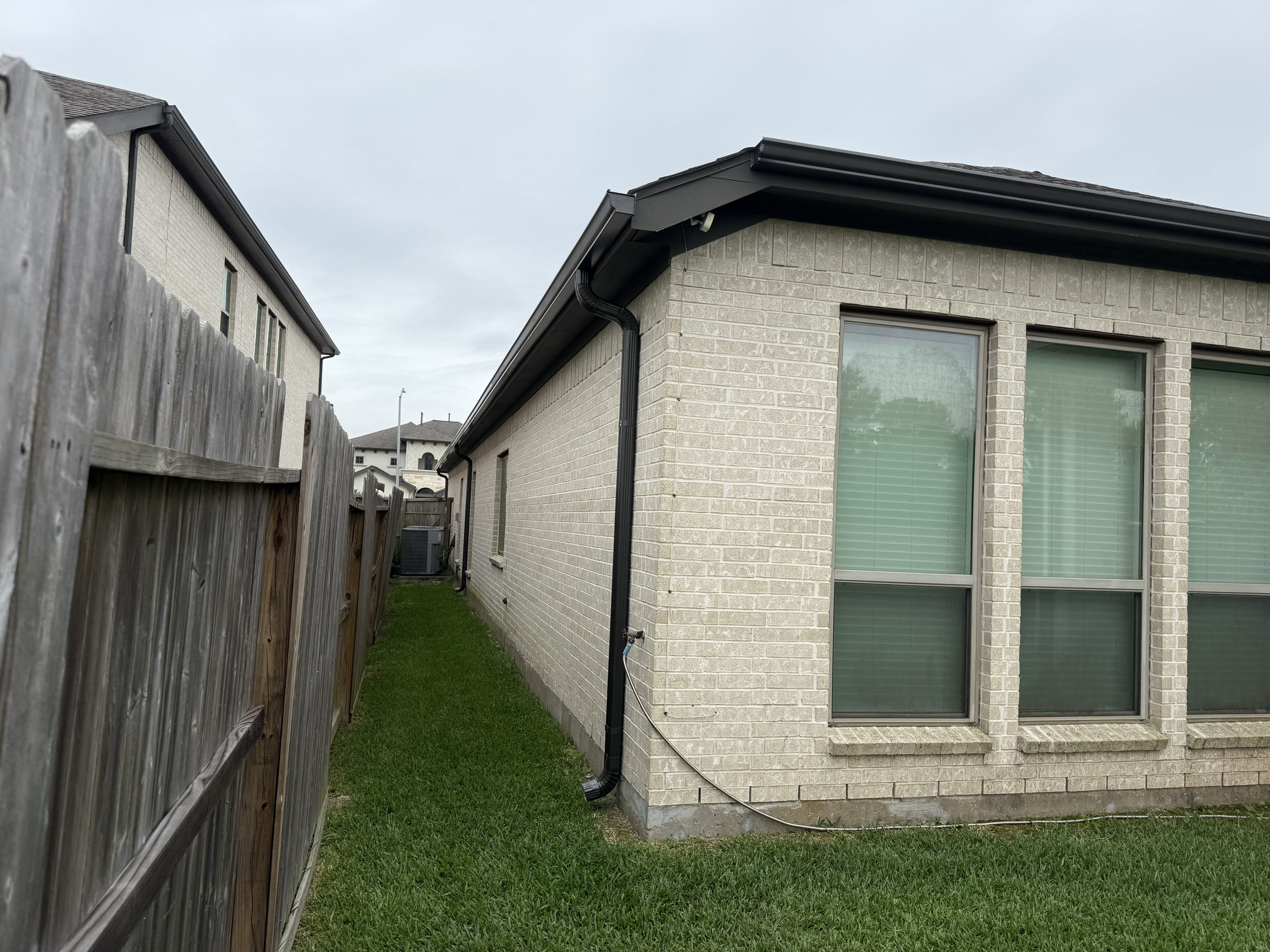 Black gutters on cream brick home