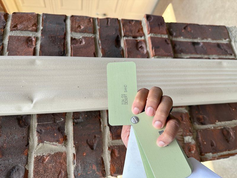 Matching aluminum gutter color swatches against brick