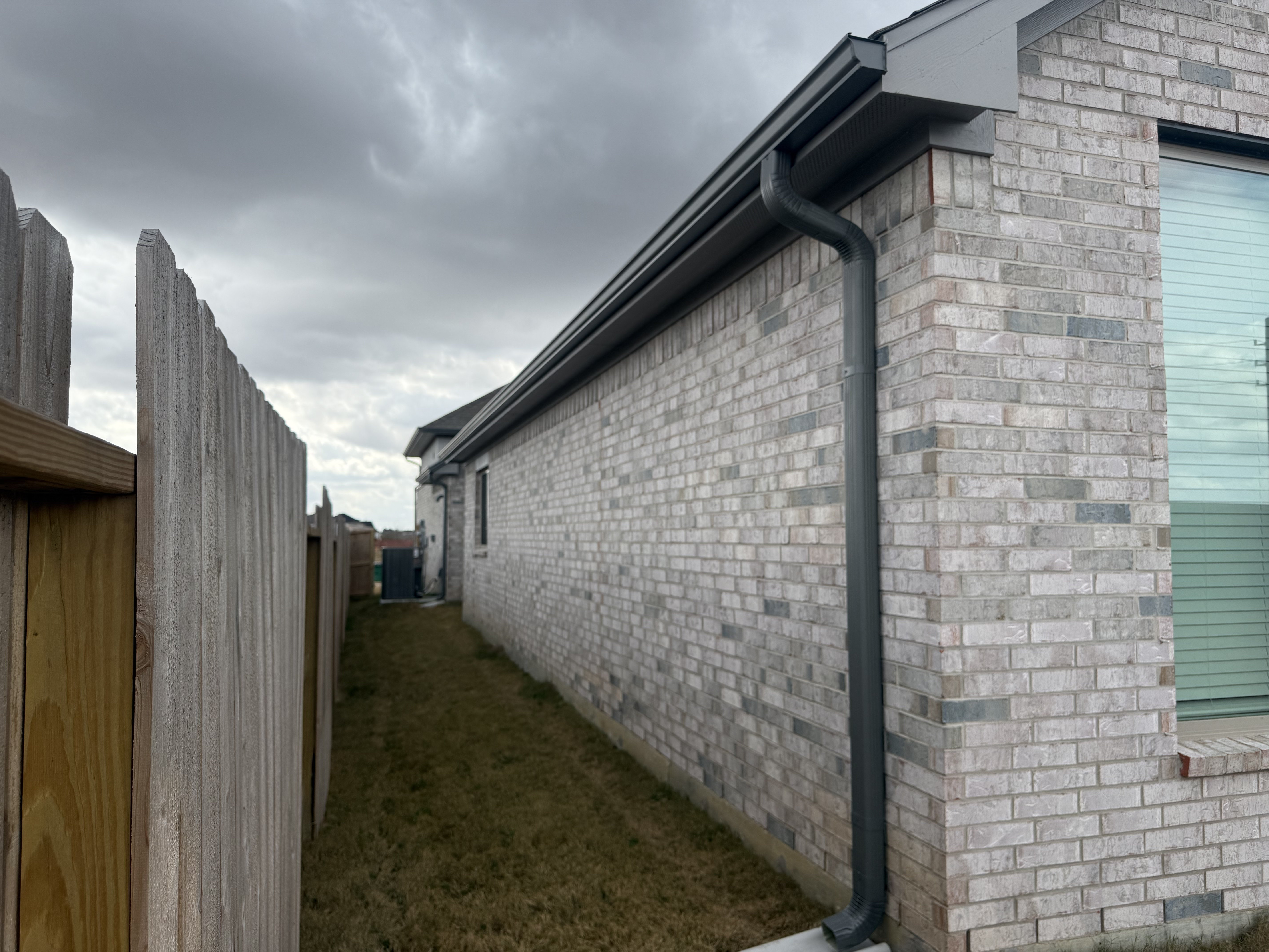 Dark charcoal gutters on brick home