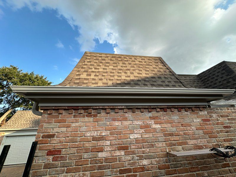 Close-up of seamless gutter installed along the fascia of a brick home