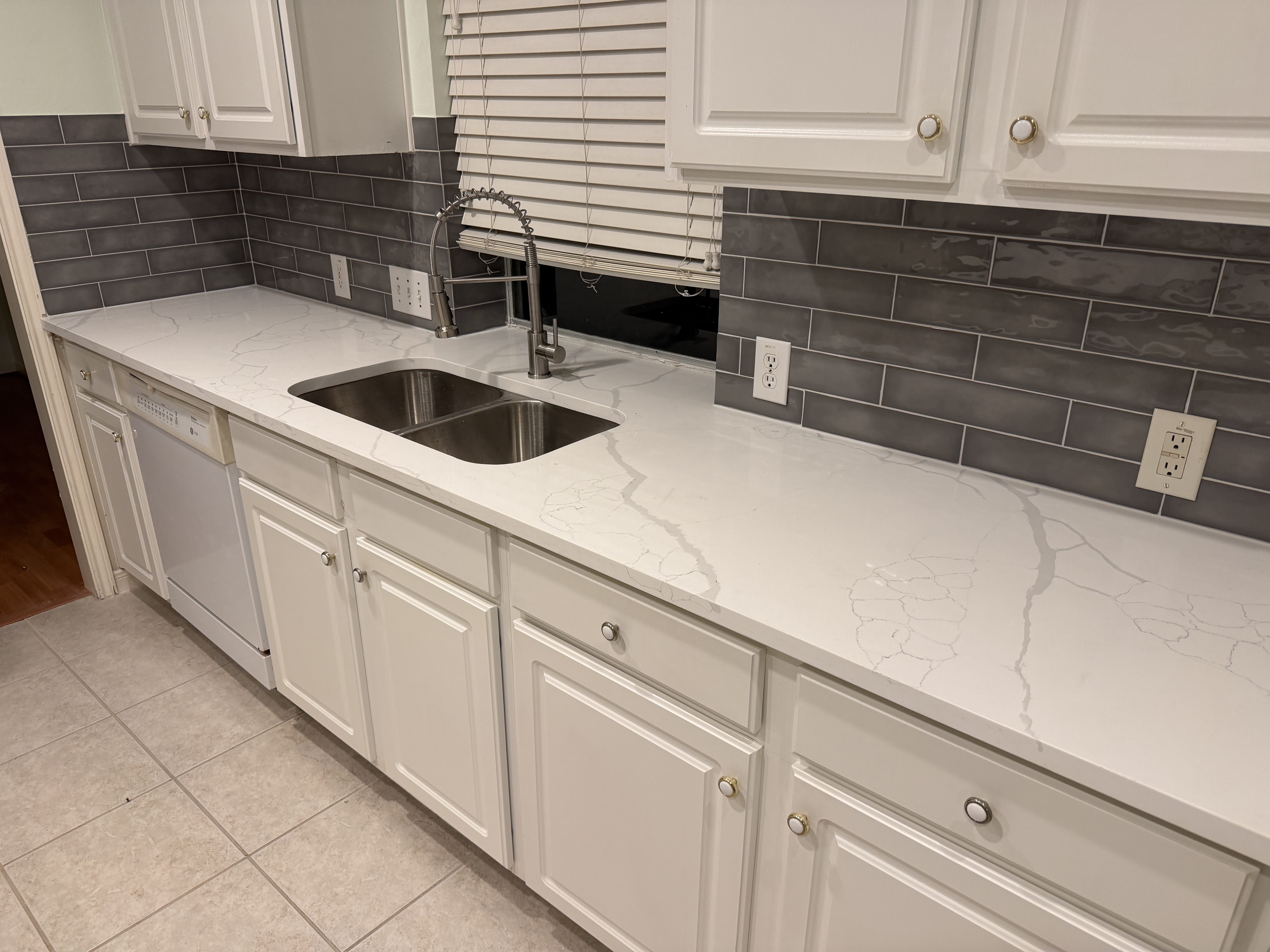 Quartz countertop and backsplash around kitchen sink